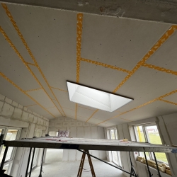 Montering af gipsloft med præcise målinger under husrenovering.