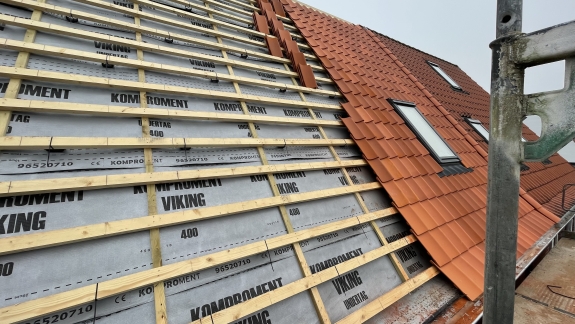 Nyt tag med røde teglsten under montering.