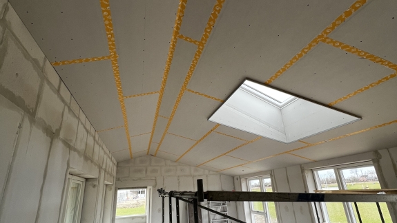 Renovering af hus med nyt gipsloft og stort ovenlysvindue.