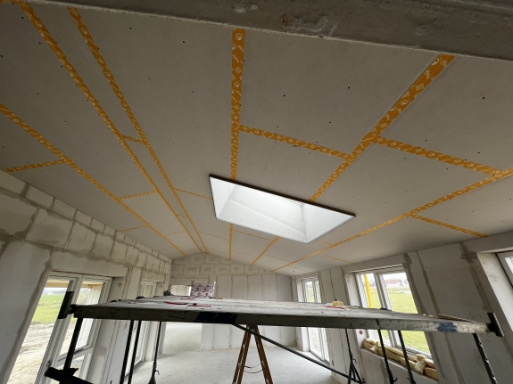 Montering af gipsloft med præcise målinger under husrenovering.